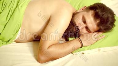 <strong>帅哥</strong>睡觉，抱着柔软的绿色枕头的照片。 <strong>帅哥</strong>睡在卧室里-躺在床上。 青年